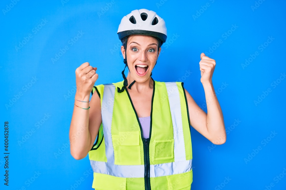 Young caucasian girl wearing bike helmet and reflective vest screaming proud, celebrating victory and success very excited with raised arms Young caucasian girl wearing bike helmet and reflective vest screaming proud, celebrating victory and success very excited with raised arms