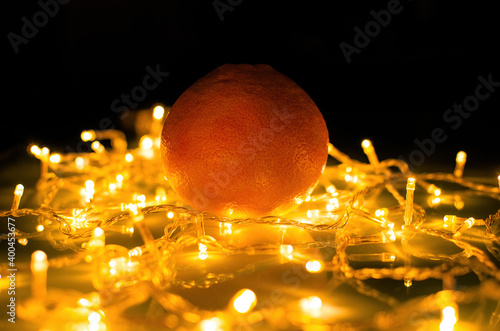 Tangerine on a background of garlands on the table