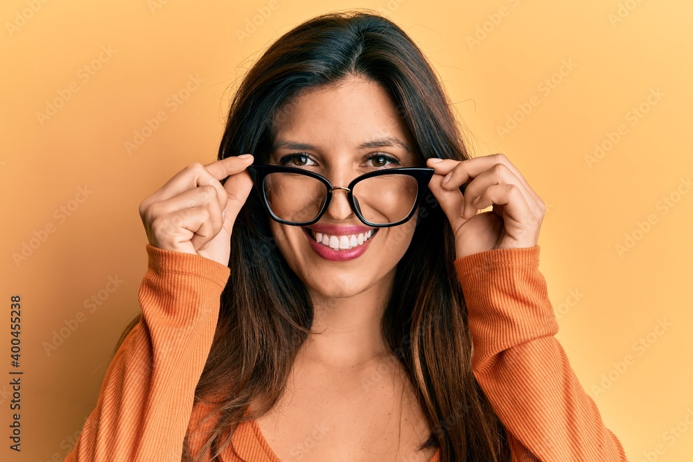 Beautiful hispanic woman wearing glasses smiling with a happy and cool smile on face. showing teeth. Beautiful hispanic woman wearing glasses smiling with a happy and cool smile on face. showing teeth.