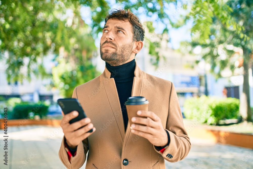 Handsome business man wearing elegant jacket using smartphone outdoors Handsome business man wearing elegant jacket using smartphone outdoors