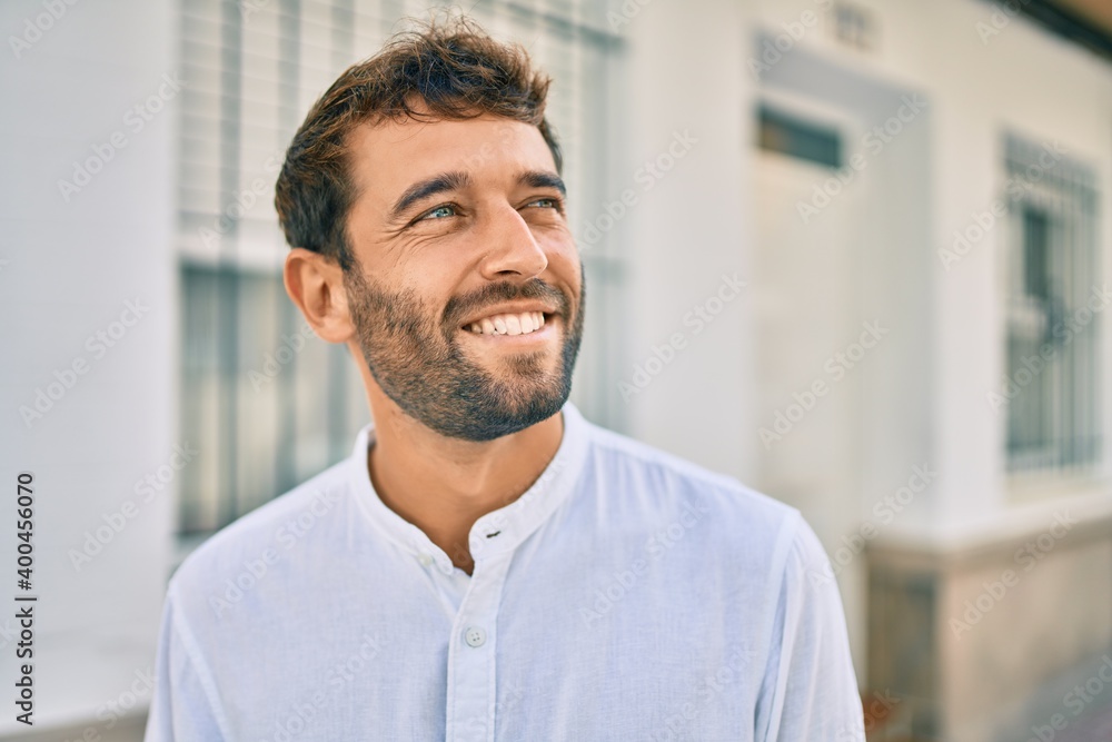 Handsome man with beard wearing casual white shirt on a sunny day smiling happy outdoors Handsome man with beard wearing casual white shirt on a sunny day smiling happy outdoors