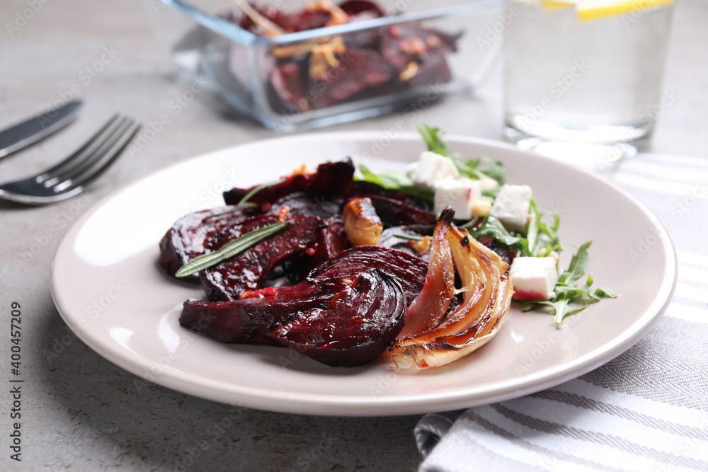 Roasted beetroot slices with, onion feta cheese and arugula on light grey table, closeup Roasted beetroot slices with, onion feta cheese and arugula on light grey table, closeup