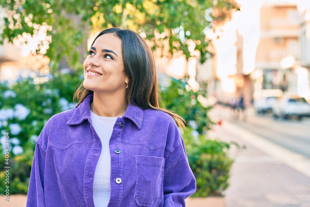 Young hispanic woman smiling happy walking at the park.