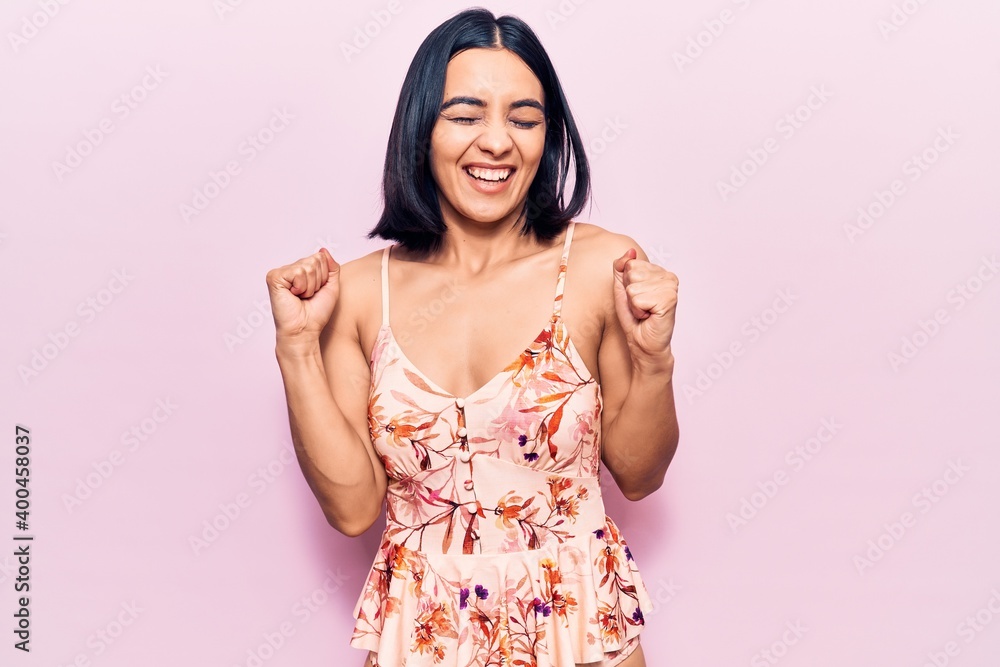 Young beautiful latin woman wearing casual clothes excited for success with arms raised and eyes closed celebrating victory smiling. winner concept. Young beautiful latin woman wearing casual clothes excited for success with arms raised and eyes closed celebrating victory smiling. winner concept.