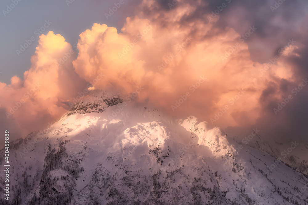 Beautiful aerial landscape view of Mountain Peaks near Vancouver, British Columbia, Canada. Dramatic Stormy Cloudy Sunset Sky Art Render.