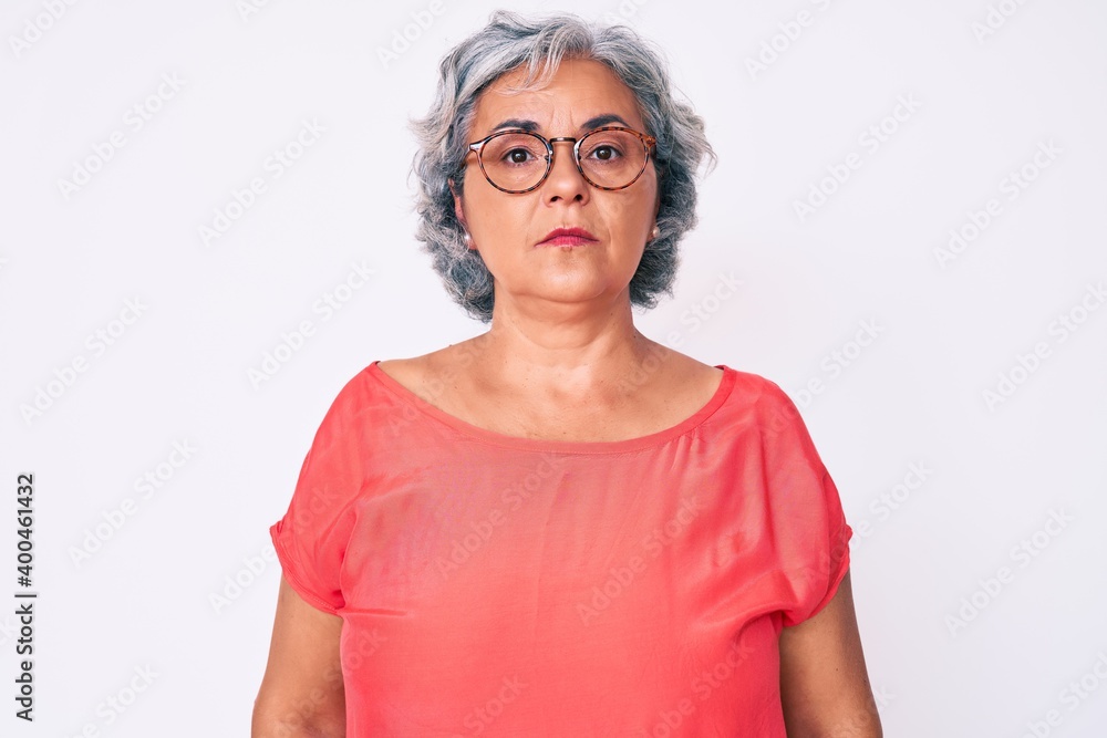 Senior hispanic grey- haired woman wearing casual clothes and glasses relaxed with serious expression on face. simple and natural looking at the camera. Senior hispanic grey- haired woman wearing casual clothes and glasses relaxed with serious expression on face. simple and natural looking at the camera.