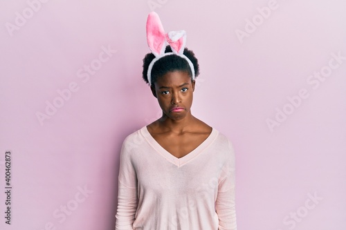 Young african american girl wearing cute easter bunny ears depressed and worry for distress, crying angry and afraid. sad expression.