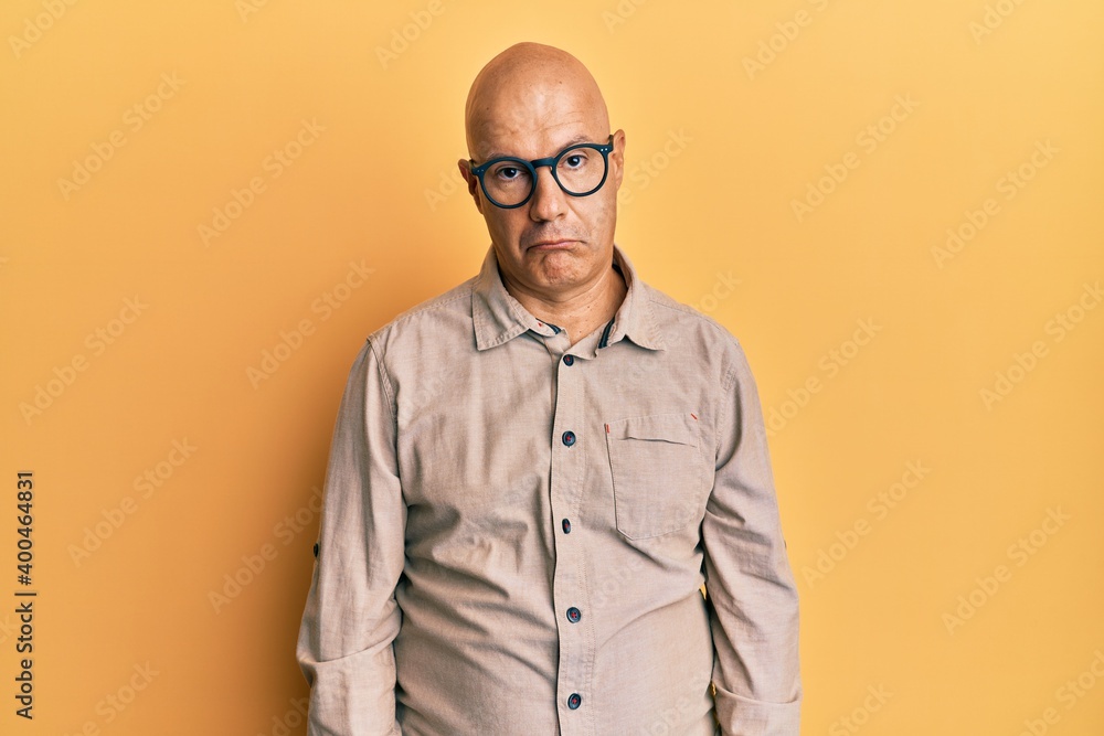 Fototapeta premium Middle age bald man wearing casual clothes and glasses depressed and worry for distress, crying angry and afraid. sad expression.