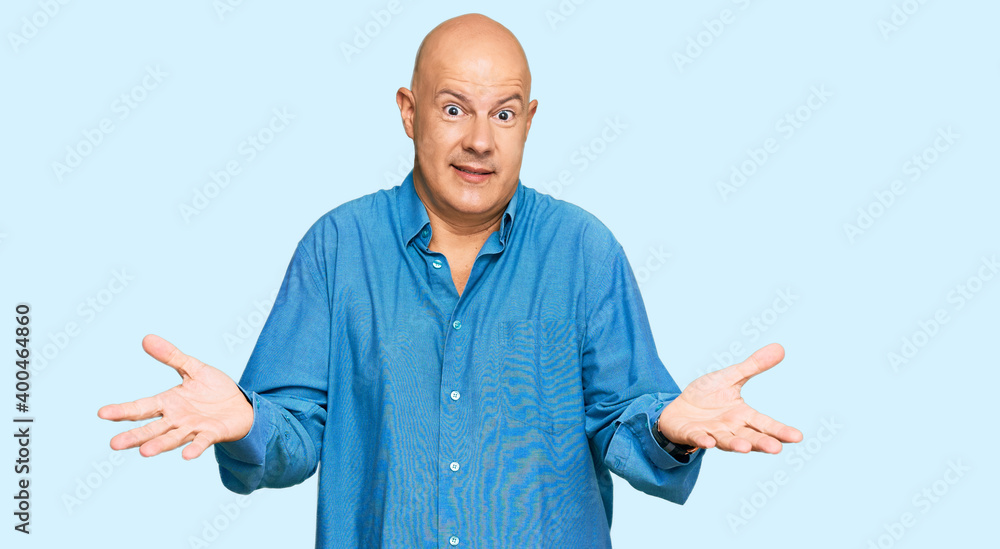 Middle age bald man wearing casual clothes smiling cheerful with open arms as friendly welcome, positive and confident greetings Middle age bald man wearing casual clothes smiling cheerful with open arms as friendly welcome, positive and confident greetings