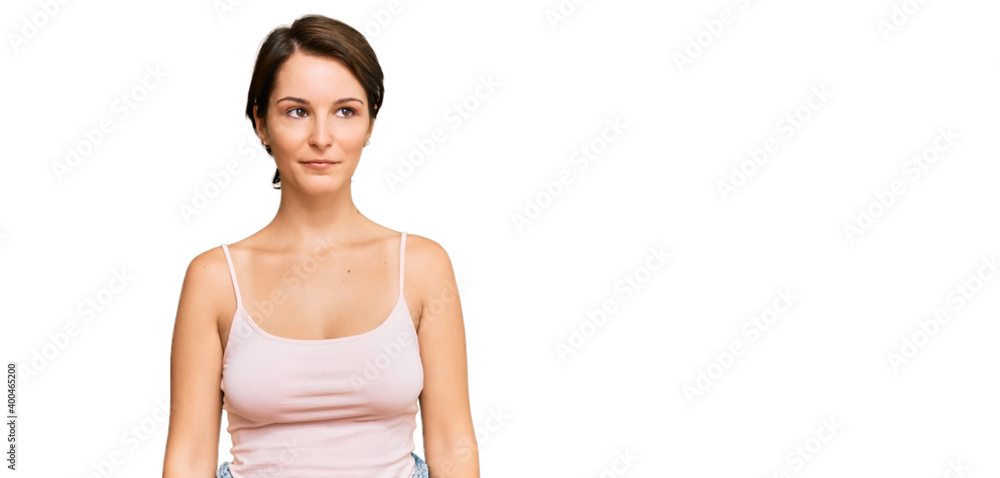 Young brunette woman with short hair wearing casual summer clothes with serious expression on face. simple and natural looking at the camera. Young brunette woman with short hair wearing casual summer clothes with serious expression on face. simple and natural looking at the camera.
