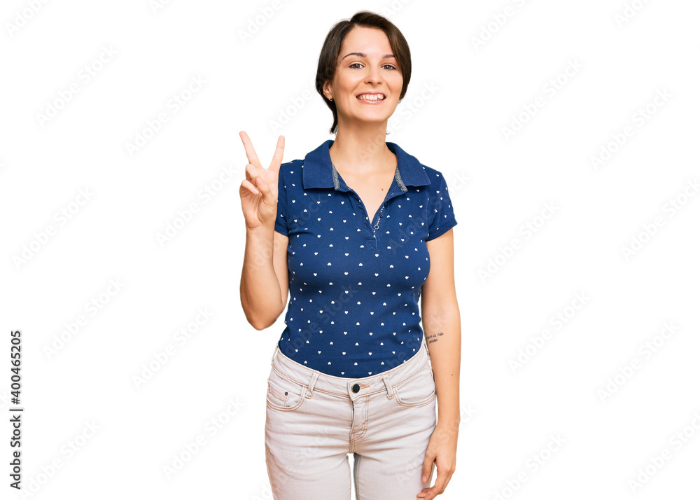 Young brunette woman with short hair wearing casual clothes showing and pointing up with fingers number two while smiling confident and happy. Young brunette woman with short hair wearing casual clothes showing and pointing up with fingers number two while smiling confident and happy.