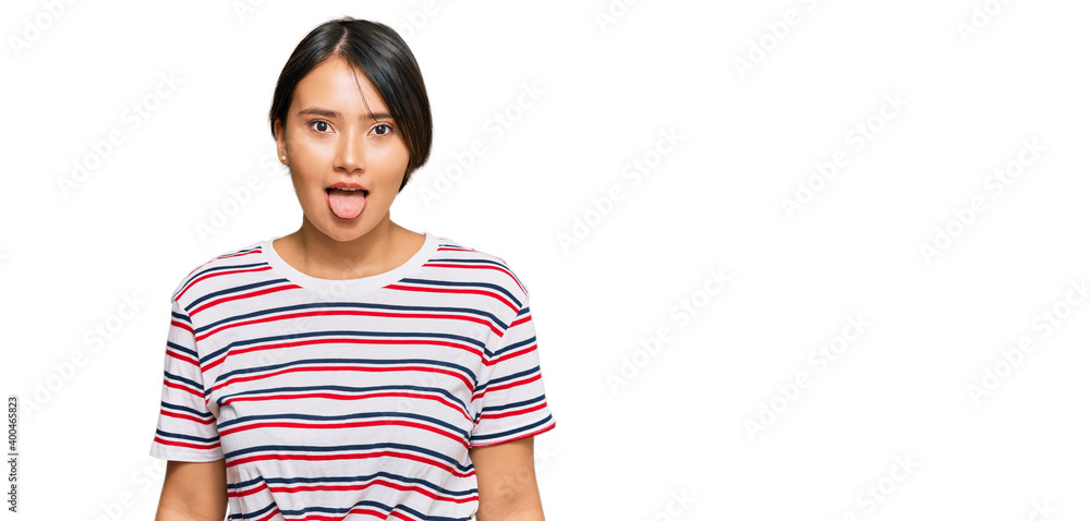 Beautiful young woman with short hair wearing casual clothes sticking tongue out happy with funny expression. emotion concept. Beautiful young woman with short hair wearing casual clothes sticking tongue out happy with funny expression. emotion concept.