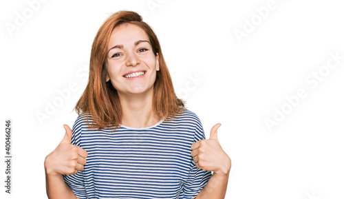 Young caucasian woman wearing casual clothes success sign doing positive gesture with hand, thumbs up smiling and happy. cheerful expression and winner gesture. © Krakenimages.com
