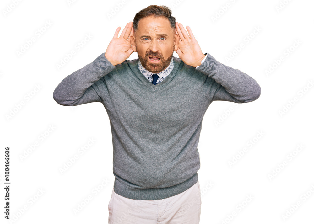 Handsome middle age man wearing business clothes trying to hear both hands on ear gesture, curious for gossip. hearing problem, deaf Handsome middle age man wearing business clothes trying to hear both hands on ear gesture, curious for gossip. hearing problem, deaf