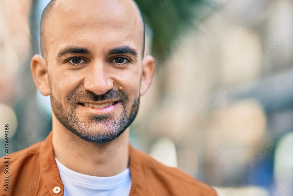 Young hispanic bald man smiling happy standing at the city. Young hispanic bald man smiling happy standing at the city.