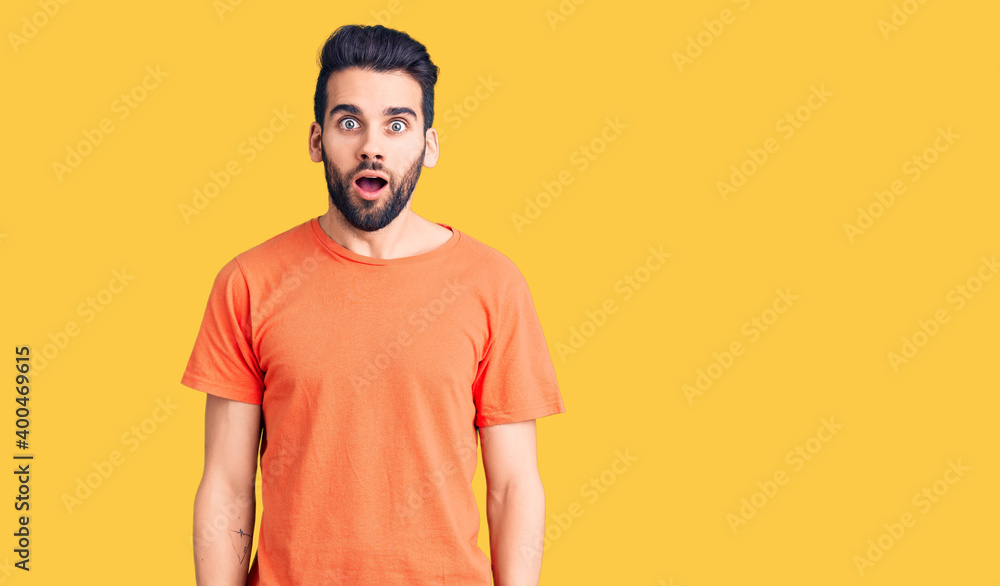 Young handsome man with beard wearing casual t-shirt afraid and shocked with surprise and amazed expression, fear and excited face. Young handsome man with beard wearing casual t-shirt afraid and shocked with surprise and amazed expression, fear and excited face.