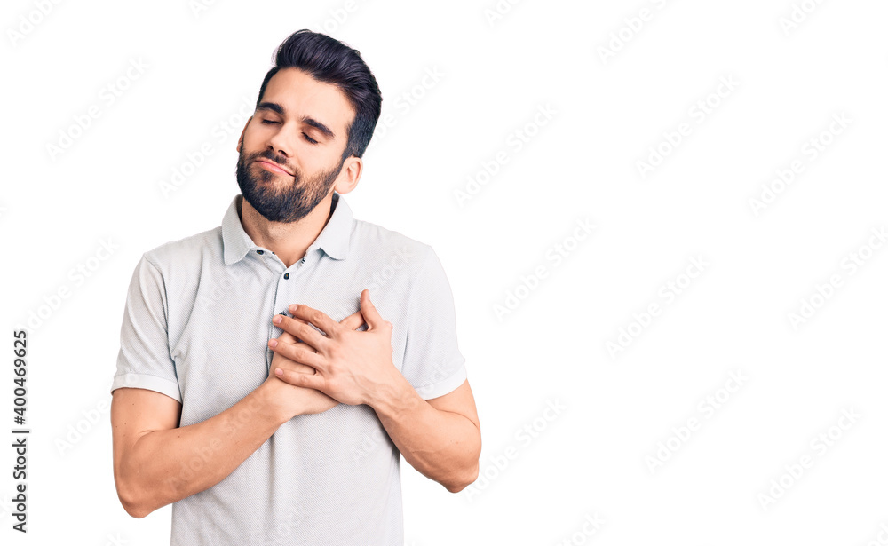 Young handsome man with beard wearing casual polo smiling with hands on chest with closed eyes and grateful gesture on face. health concept. Young handsome man with beard wearing casual polo smiling with hands on chest with closed eyes and grateful gesture on face. health concept.