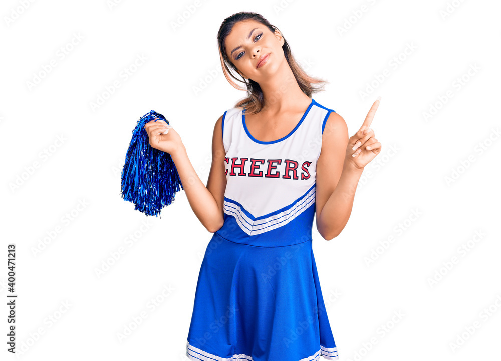 Young beautiful woman wearing cheerleader uniform pointing finger up with successful idea. exited and happy. number one. Young beautiful woman wearing cheerleader uniform pointing finger up with successful idea. exited and happy. number one.