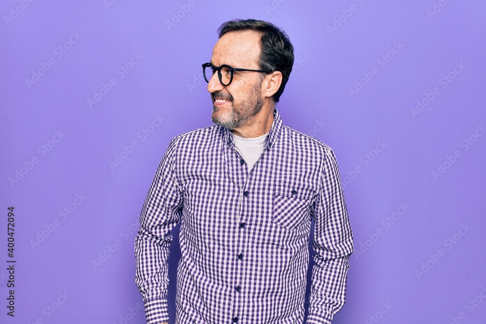 Fototapeta premium Middle age handsome man wearing casual shirt and glasses over isolated white background looking to side, relax profile pose with natural face and confident smile.