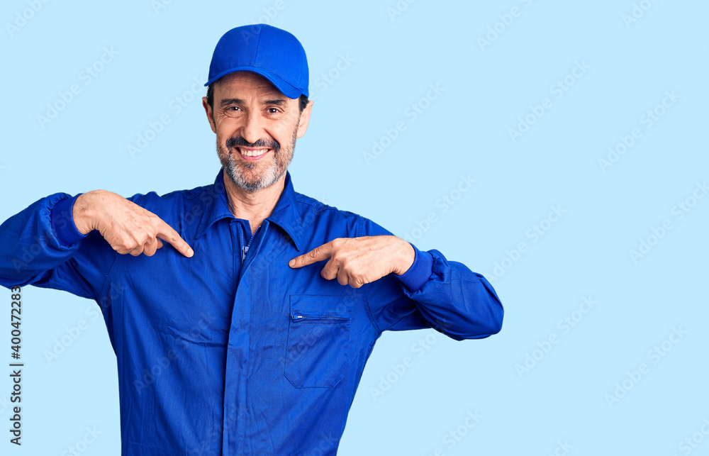 Middle age handsome man wearing mechanic uniform looking confident with smile on face, pointing oneself with fingers proud and happy. Middle age handsome man wearing mechanic uniform looking confident with smile on face, pointing oneself with fingers proud and happy.
