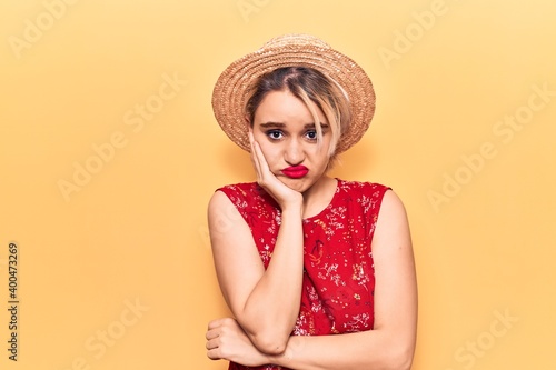 Young beautiful blonde woman wearing summer hat thinking looking tired and bored with depression problems with crossed arms.