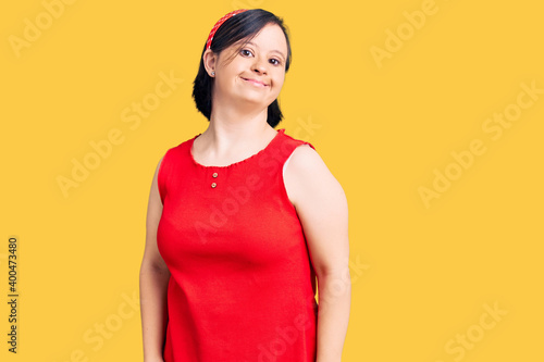 Brunette woman with down syndrome wearing casual clothes looking positive and happy standing and smiling with a confident smile showing teeth
