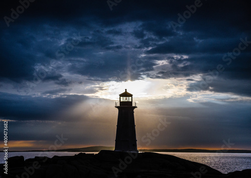 Peggy's Cove lighthouse at sunset with storm clouds