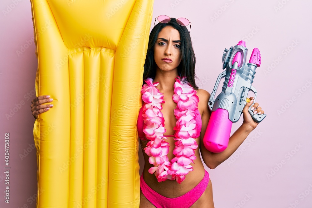 Obraz premium Beautiful hispanic woman wearing swimsuit and holding summer float skeptic and nervous, frowning upset because of problem. negative person.