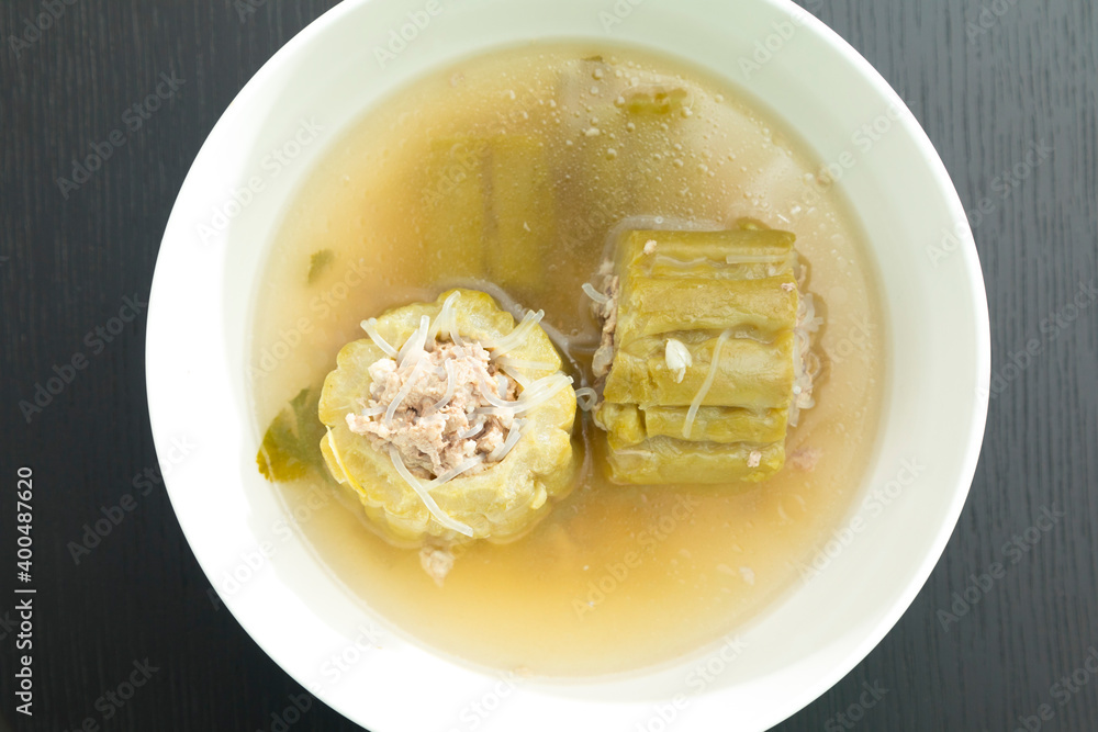 Thai food, bitter gourd soup with pork in a bowl on wooden table. Thai food, bitter gourd soup with pork in a bowl on wooden table.