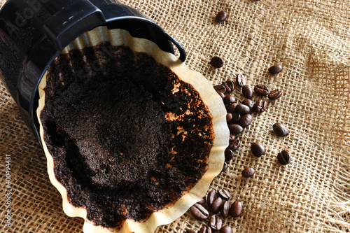 Billede på lærred An image of a used coffee filter with coffee basket and coffee beans on burlap