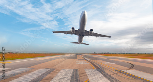 White Passenger plane fly up over take-off runway from airport 