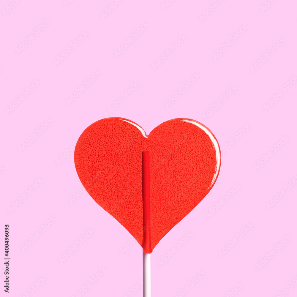 Lollipop heart isolated on pink background. Sweet red heart shape candy on stick, symbol of love. Valentine's day gift. 14 february concept. 