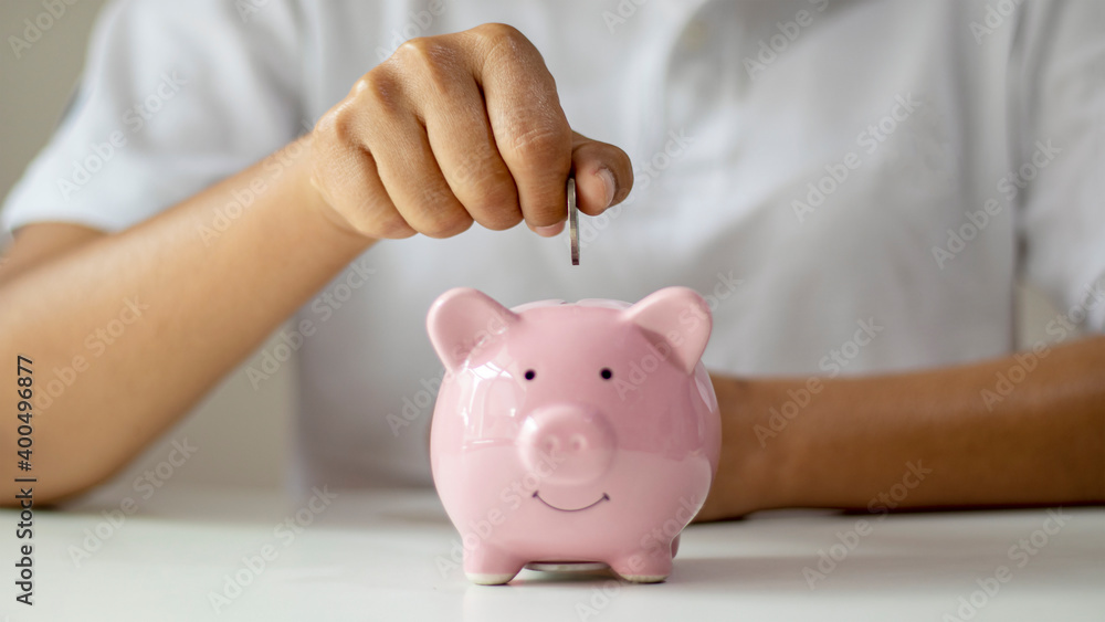 Women put silver coins into piglets to save money and save money for future investment. Financial concept. Women put silver coins into piglets to save money and save money for future investment. Financial concept.