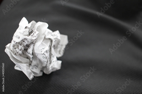 Receipts obtained from shopping from a department store Being crumpled and placed on a gray cloth Use your hand to hold the receipt