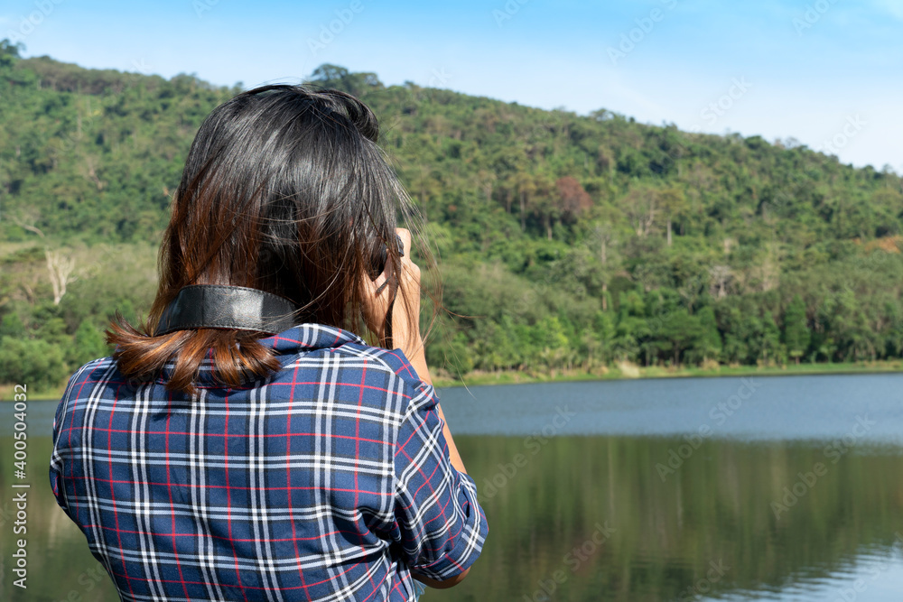 woman standing back to take a picture at a reservoir with green mountains in the background. Ang Kep Nam Huai Hin Dat Rayong Thailand. woman standing back to take a picture at a reservoir with green mountains in the background. Ang Kep Nam Huai Hin Dat Rayong Thailand.