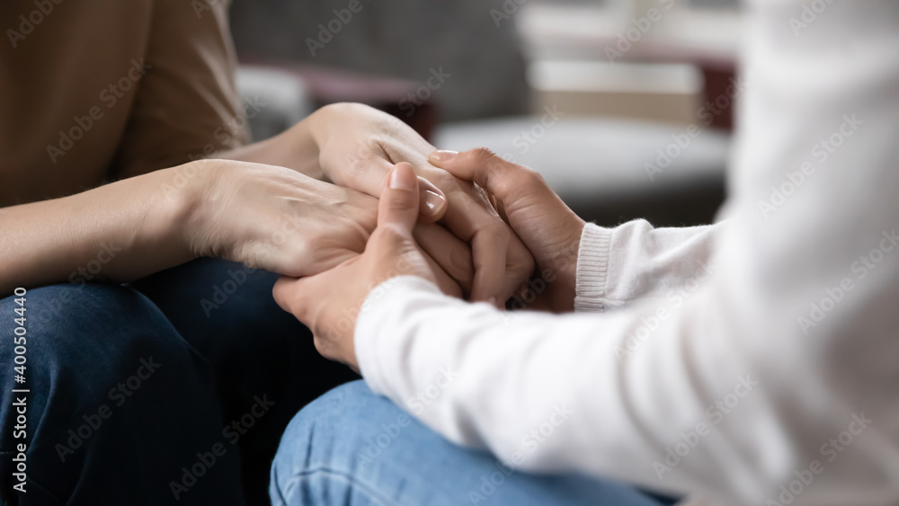 Close up grownup daughter holding mature mother hands, expressing support and care, granddaughter caregiver comforting older grandmother, good trusted family relationship, two generations bonding