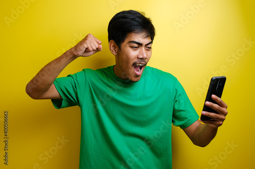 Attractive young Asian man have good news on his phone