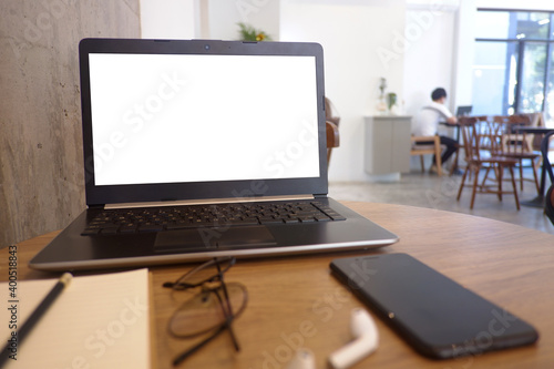 Fotografie Front view of wooden office desk with the labtop, keyboard, smart phone and the