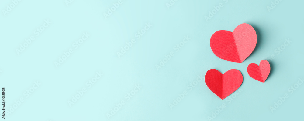 Paper hearts over the blue pastel background, copy space. Abstract background with paper cut shapes. Sainte Valentine, mother's day, birthday wedding greeting cards, invitation, celebration banner