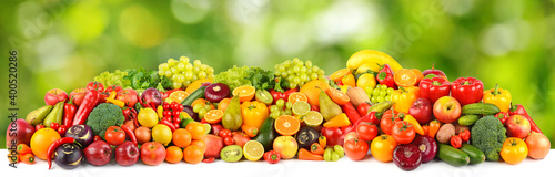 Wide pattern of ripe and fresh fruits and vegetables on green background.