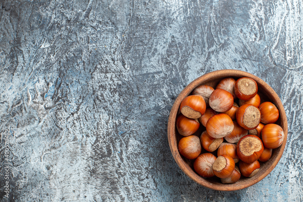 Obraz premium top view fresh hazelnuts inside plate on a white background nut walnut peanut