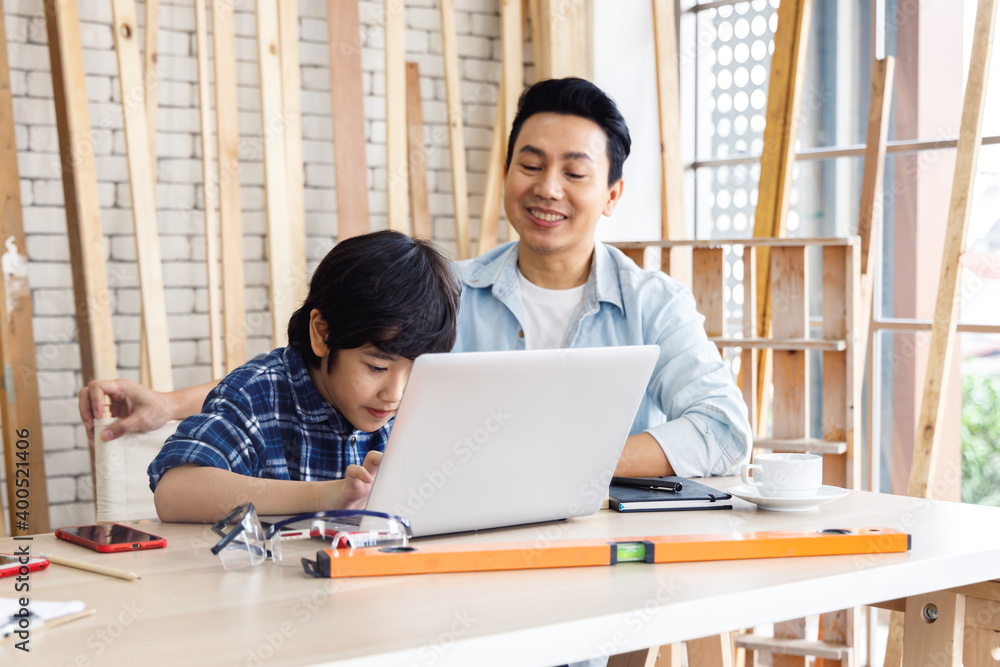 Asian father and son using laptop computer together. Asian father and son using laptop computer together.