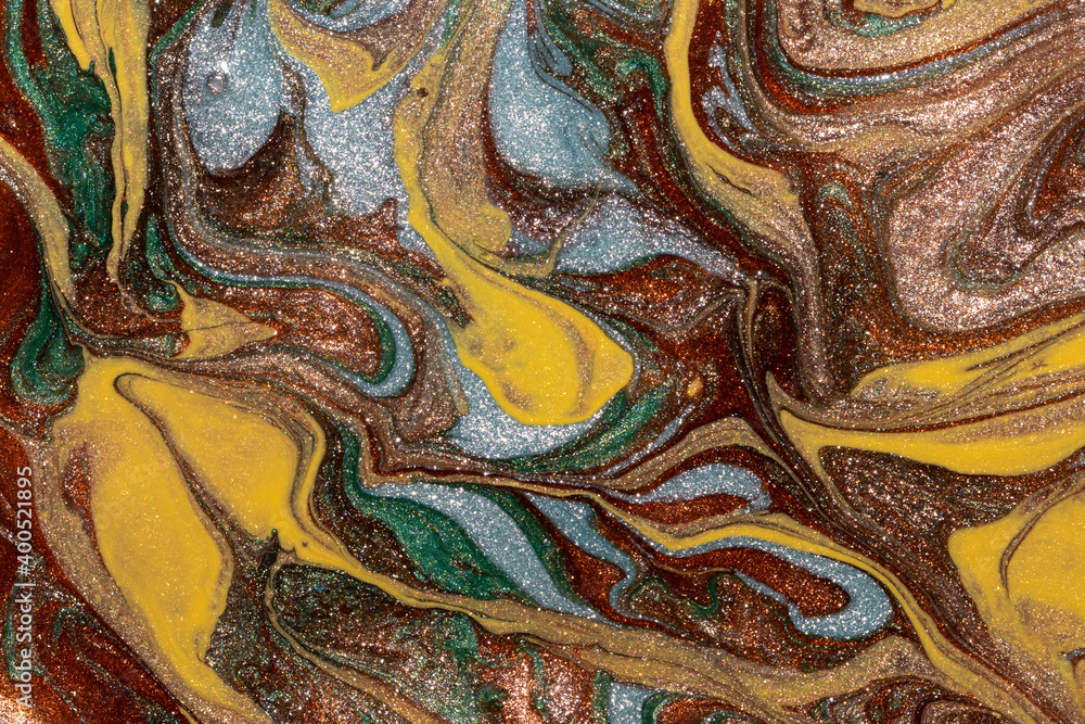 Abstract background of mixed shades of nail polish with a shiny marble pattern. Liquid colorful paint background creative brown bronze with shimmer, brown, yellow, green and blue