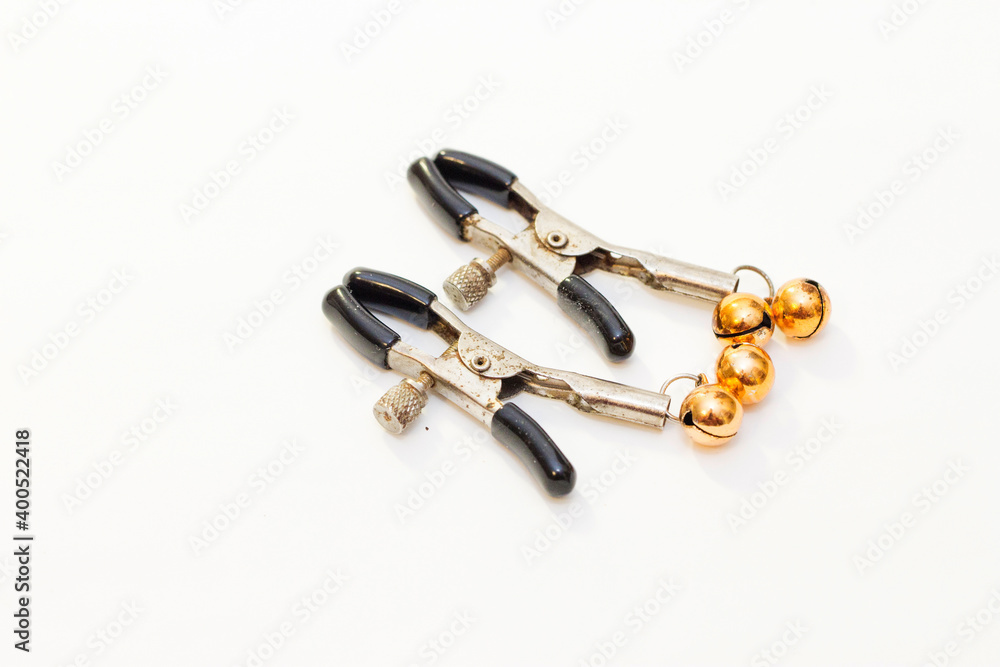 Two nipple clamps for BDSM games isolated on a white background Two nipple clamps for BDSM games isolated on a white background