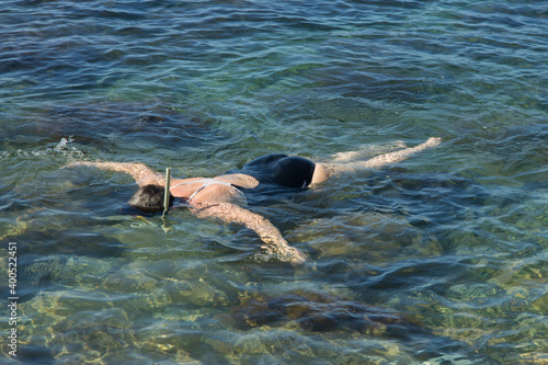Adult woman diving into clear water of sea
