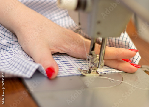 Woman taylor is working on a sewing machine