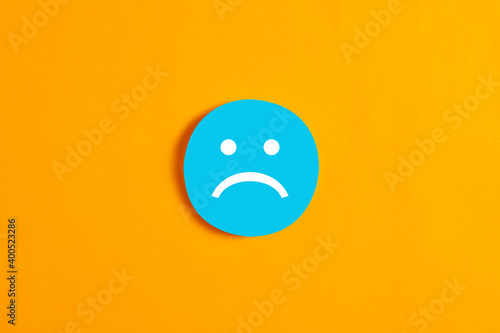 Blue round circle with a sad face icon against yellow background.