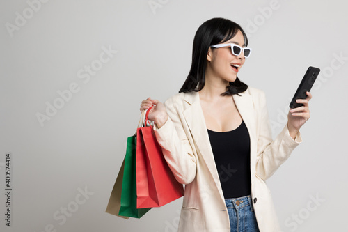 Attractive Beautiful asian woman holding shopping bag and smartp