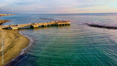 Sunset Rome aerial view in Ostia Lido beach over blue sea and brown sand  beautiful coast line with glimpse of pedestrian pier a landmark of tourist and city life