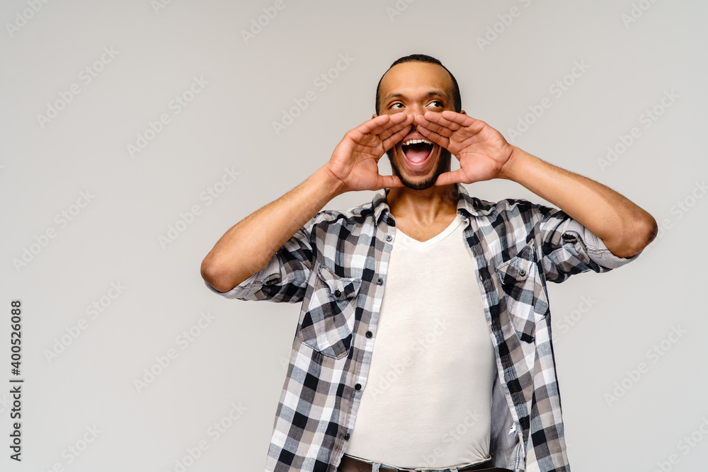 young african american man shouting against a grey background